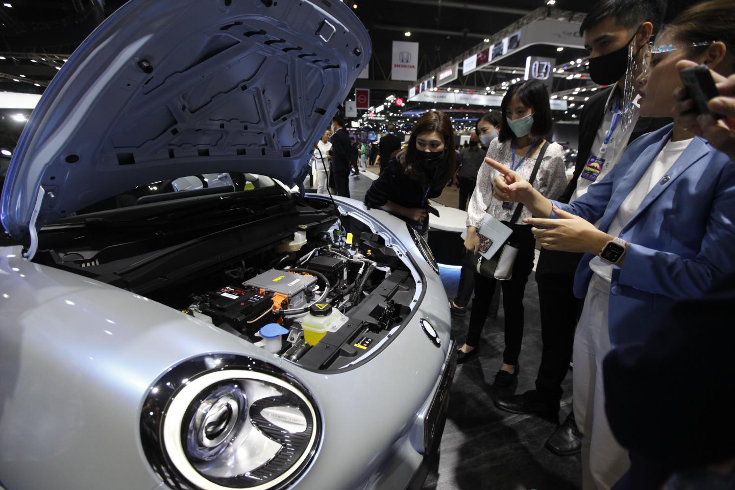 People inspect an electric vehicle at the Bangkok International Motor Show 2021 held in March and April this year. (Photo: Varuth Hirunyatheb)