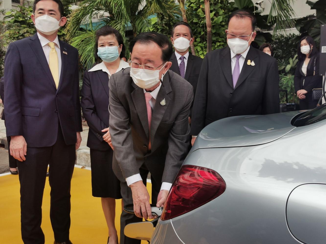 Mr Arkhom charges an electric vehicle during Egat's launch of a 500,000-baht EV charging station at the Finance Ministry on Thursday.