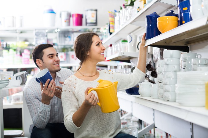 Two people looking at kitchenware in a home furnishings store. 