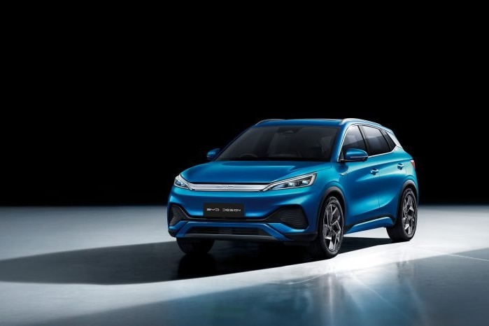 A shiny new car against a black background, it's blue with black accents is a SUV cross over body type